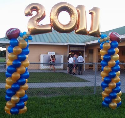 some balloons are in the shape of numbers and footballs