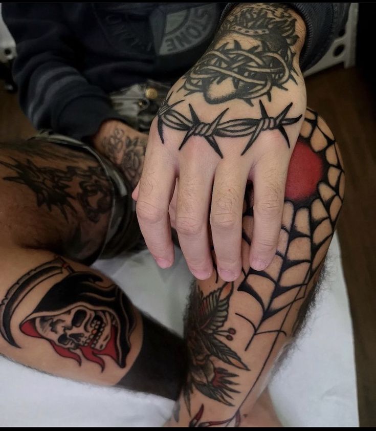 two people with tattoos on their arms and legs, one holding the other's hand