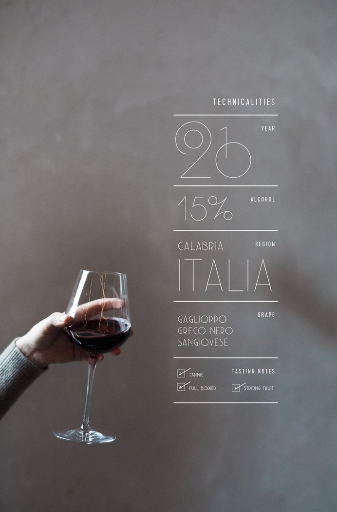 a person holding a glass of wine in front of a chalkboard with numbers on it