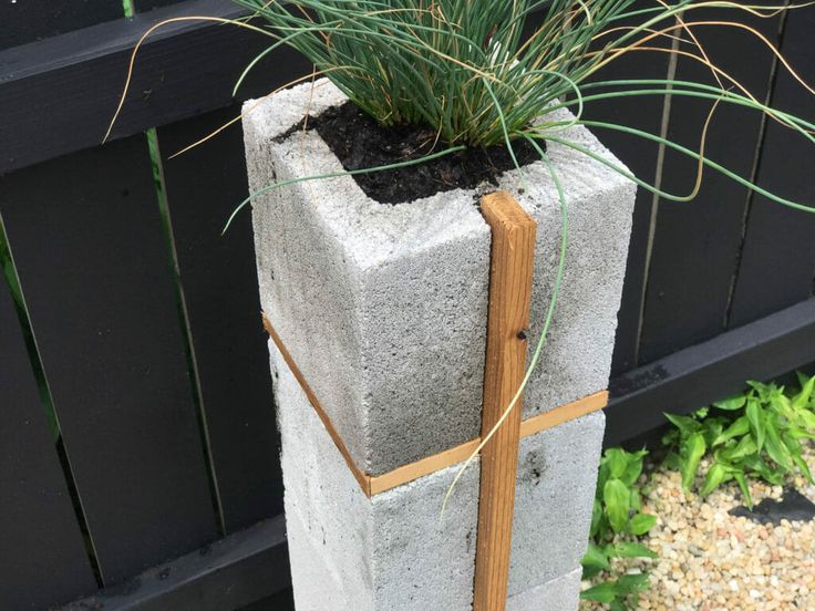 a cement planter with grass growing out of it