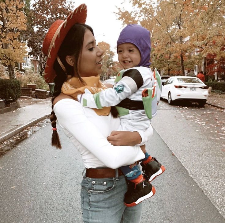 a woman holding a child in her arms on the street