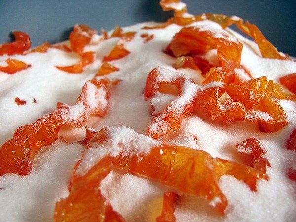 an orange cake with powdered sugar and candies on top