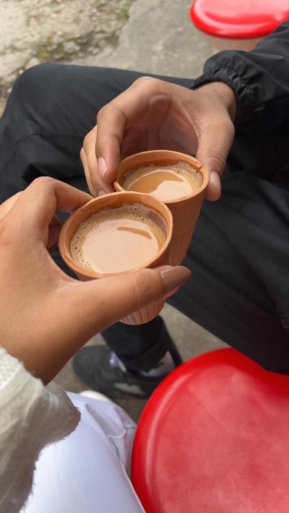 two people holding coffee cups in their hands