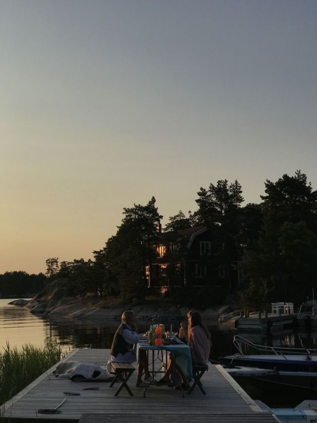 three people sitting at a table on a dock