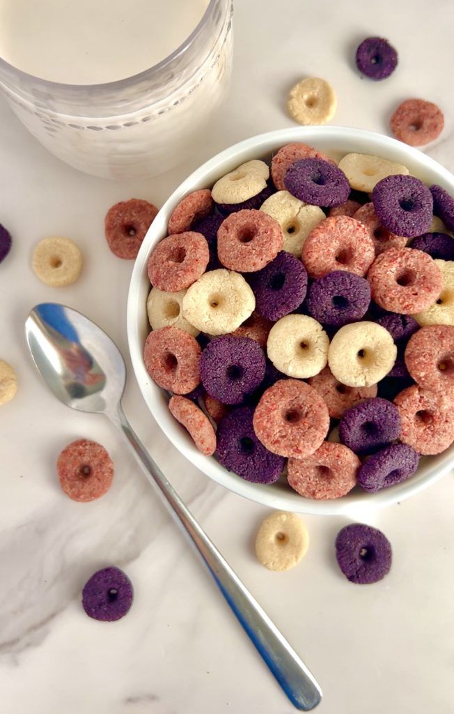 a white bowl filled with cereal next to a spoon