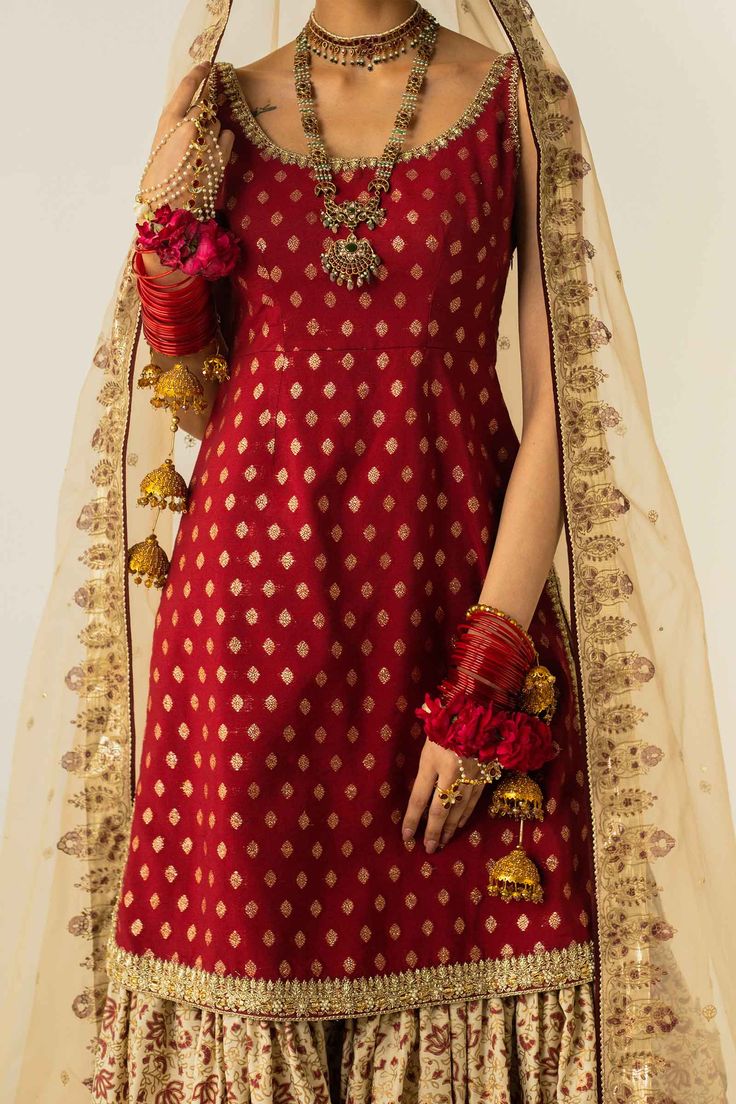 PRODUCT DESCRIPTION: Top: Zari JacquardBottom: Raw SilkDupatta: Organza This block-printed gharara with gota finishings is paired with a deep red sleeveless shirt, embellished with zardozi work on the hemline and sides. Banarasi Silk Sets With Gota Work For Reception, Traditional Brocade Palazzo Set With Zari Work, Semi-stitched Brocade Sharara With Gota Work, Festive Brocade Palazzo Set With Dupatta, Festive Brocade Palazzo Set With Pallu, Navratri Sharara With Gota Work In Jamawar, Traditional Brocade Semi-stitched Palazzo Set, Banarasi Silk Sharara For Reception In Transitional Season, Brocade Sharara With Cutdana For Reception