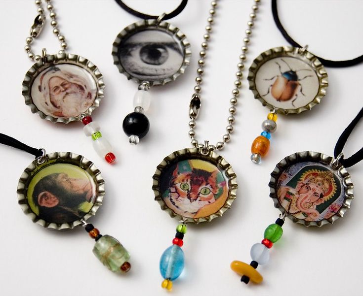 several necklaces with pictures and beads hanging from them