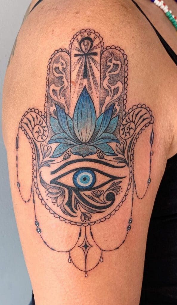 a woman's shoulder with an all seeing eye tattoo on the back of her arm