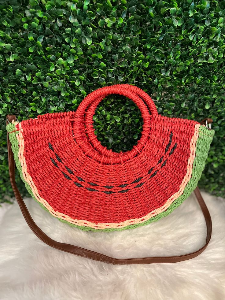 a watermelon purse sitting on top of a white fur rug