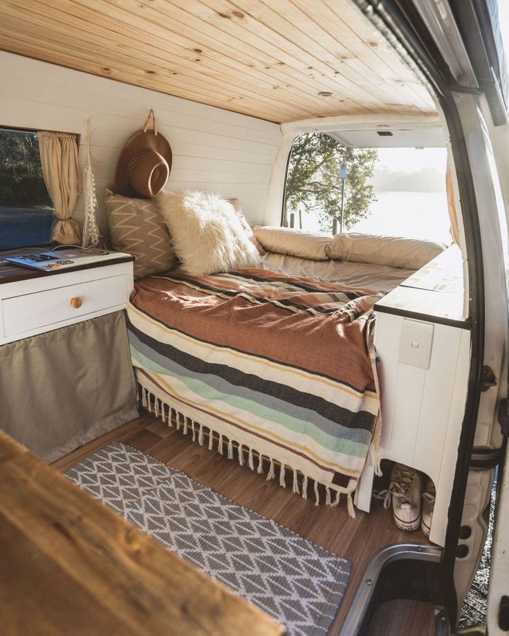 the inside of a camper with a bed and desk