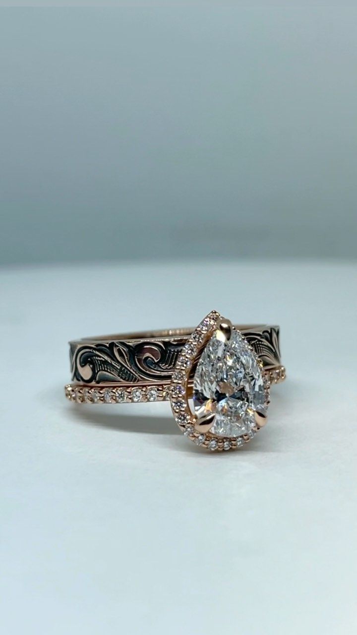 an engagement ring with a pear shaped diamond in the center and filigree band