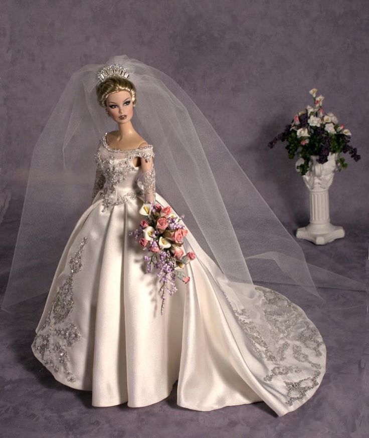 a barbie doll wearing a wedding dress and veil with flowers in the foreground on a purple background