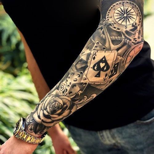 a man with a tattoo on his arm holding a clock and playing cards in front of him