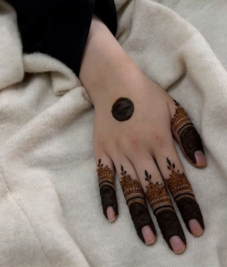 a woman's hand with henna tattoos on it