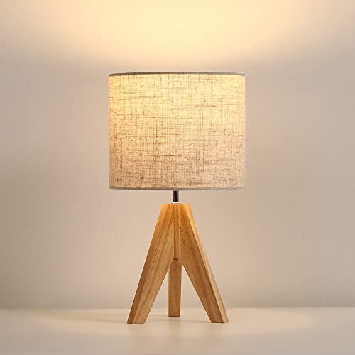 a wooden table lamp with a white shade on it's base and a light bulb in the middle