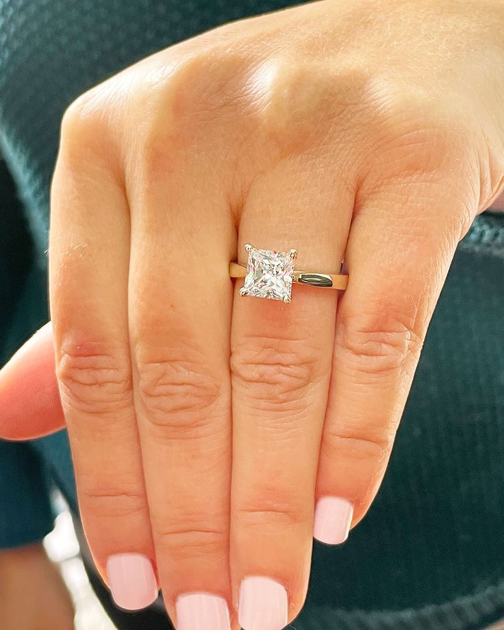 a woman's hand with a diamond ring on it