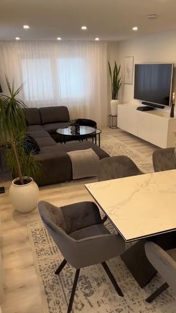 a living room filled with furniture and a flat screen tv on top of a wall