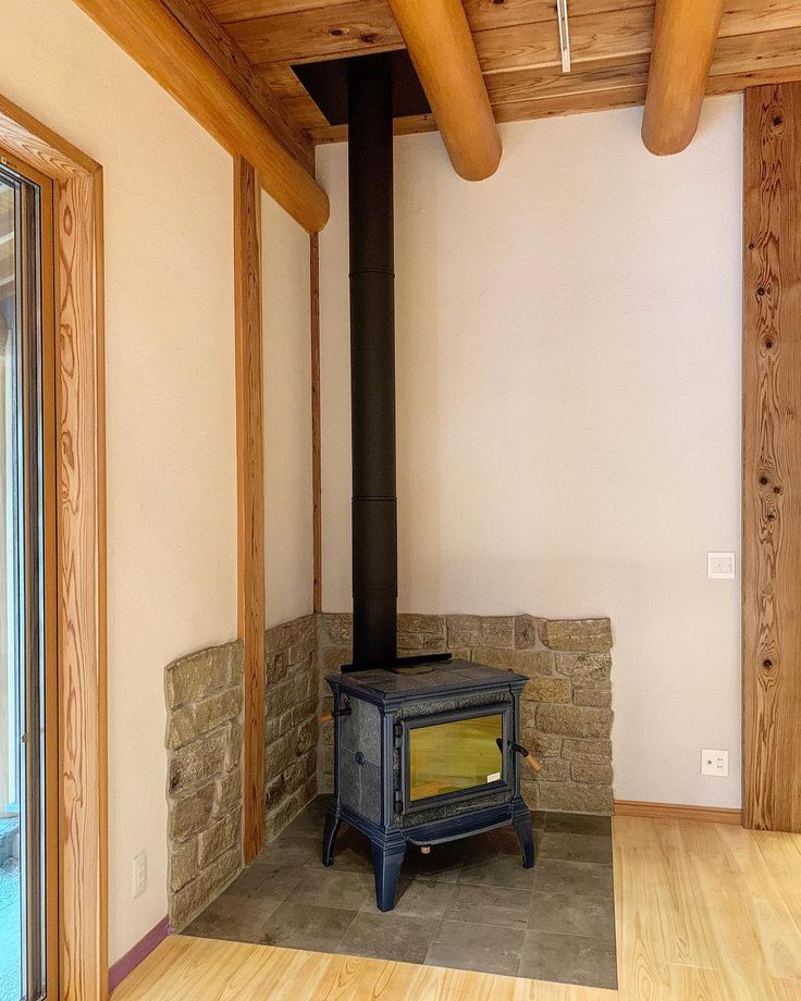 a wood burning stove sitting in the middle of a room