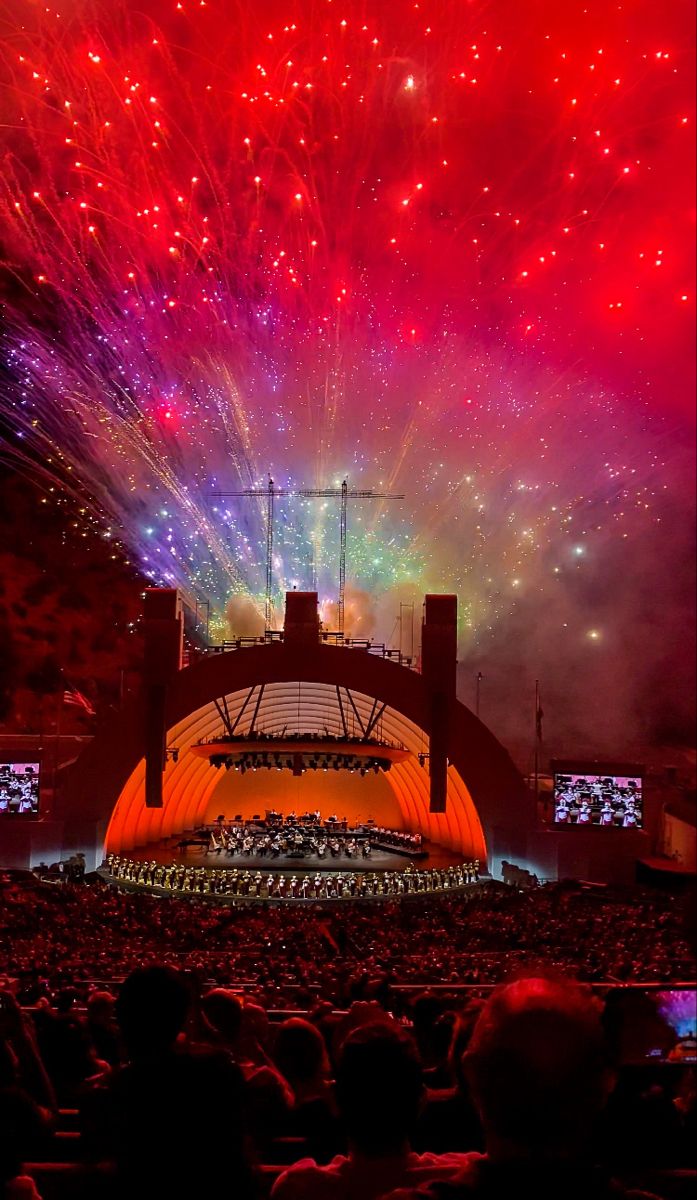 fireworks are lit up in the sky above an auditorium