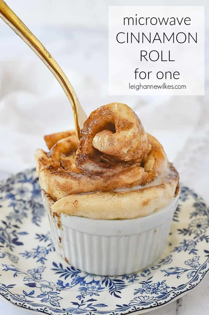 a cupcake on a blue and white plate with a golden spoon sticking out of it