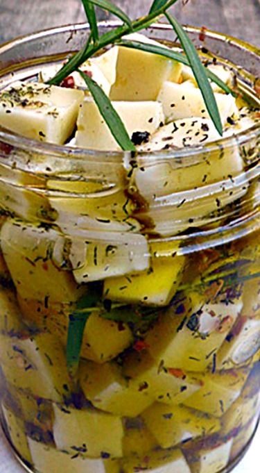 a glass jar filled with pickles and cheese