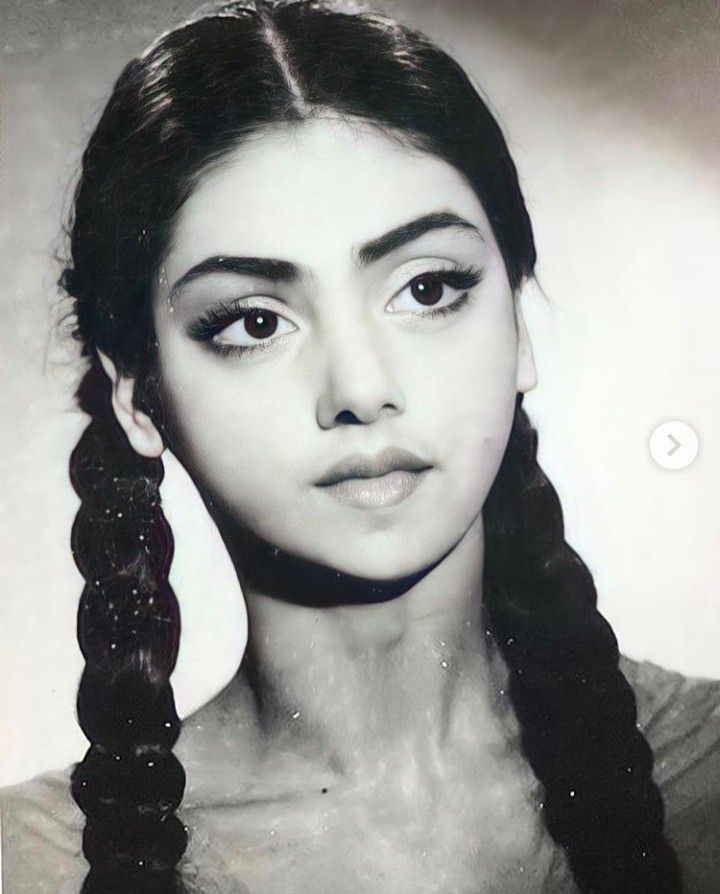 an old black and white photo of a woman with braids