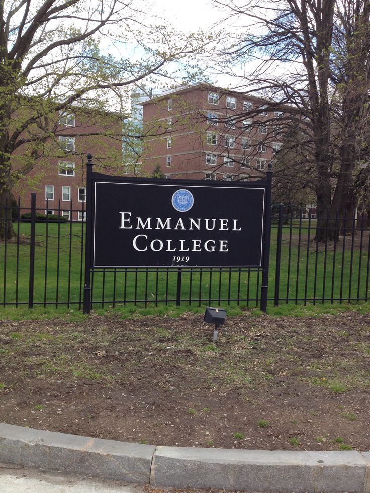 the entrance sign to the emmanuel college campus in front of a black fence