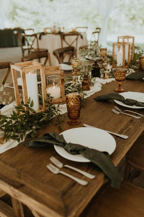 a long table with candles and plates on it