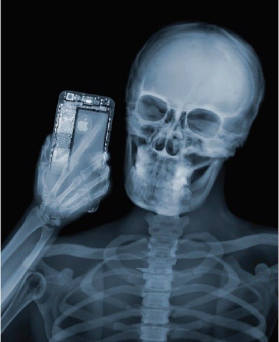 a skeleton holding a cell phone in it's right hand and looking at the screen