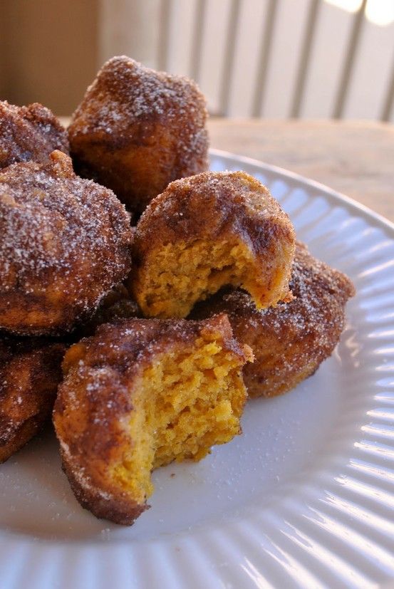 a white plate topped with donuts covered in powdered sugar