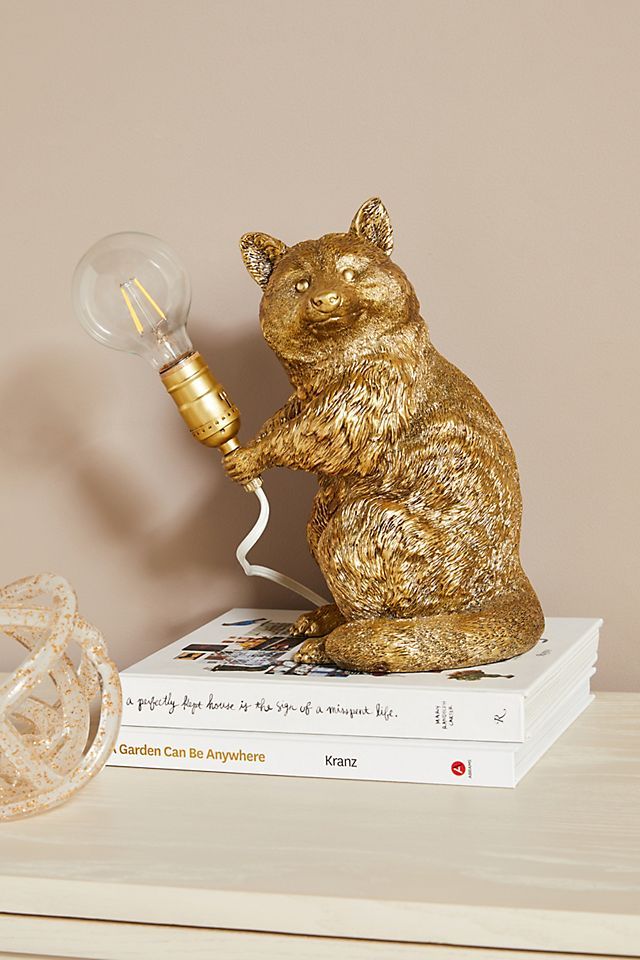 a gold bear lamp sitting on top of a stack of books