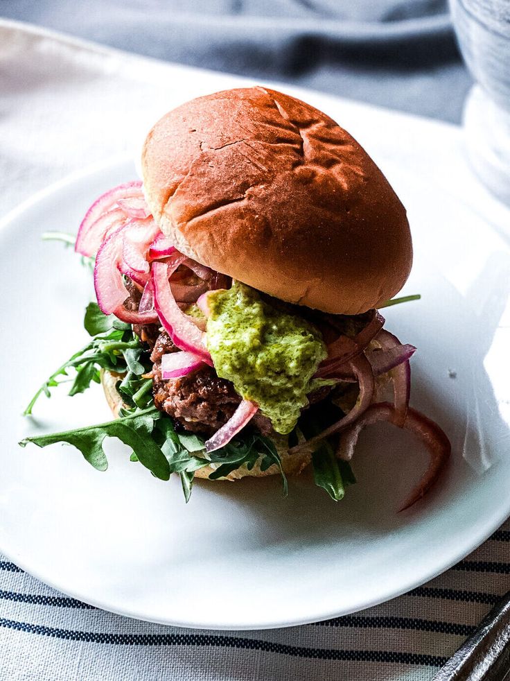 a white plate topped with a sandwich and veggies on top of lettuce