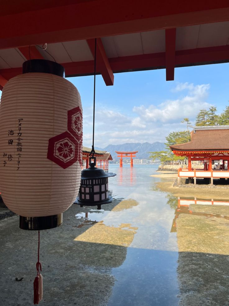 lanterns hanging from the ceiling in front of a body of water