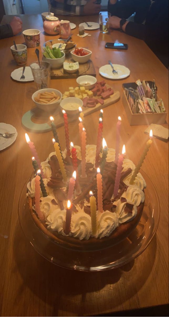 a birthday cake with lit candles sitting on a table