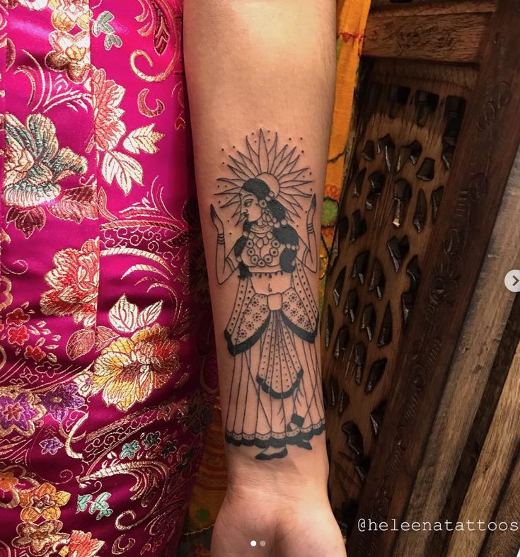 a woman's arm with a tattoo on it and an image of a lady holding a fan