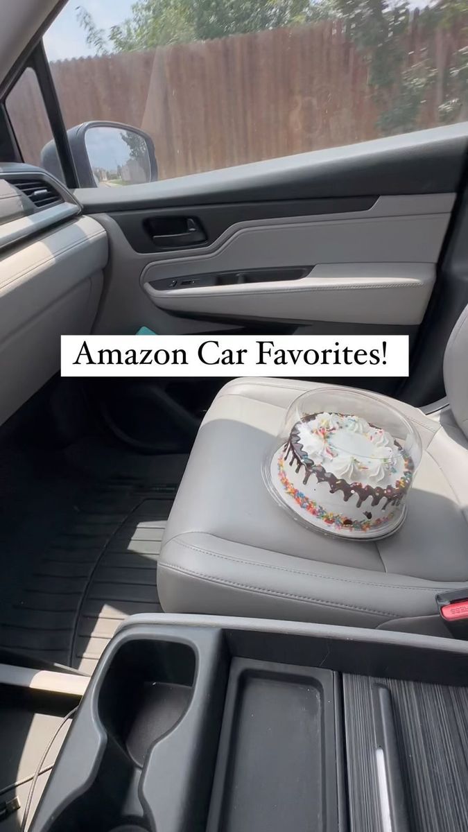 the interior of a car with a birthday cake in the back seat and an amazon gift box