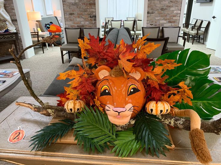 a lion head with leaves on top of it in a room filled with tables and chairs