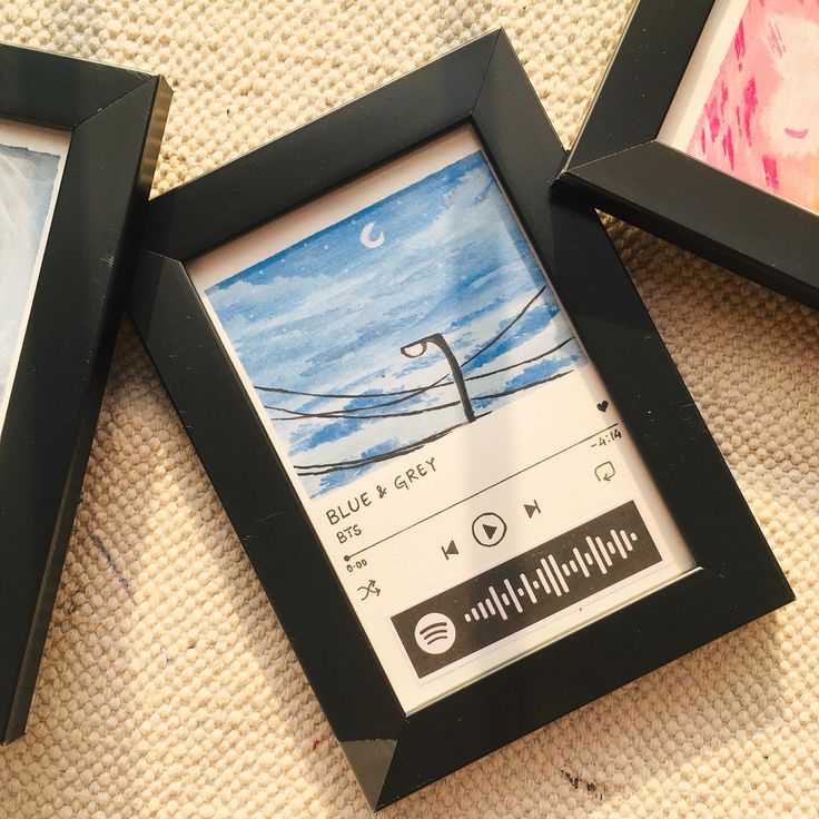 three framed pictures are sitting on the floor next to each other, one with an audio player in it