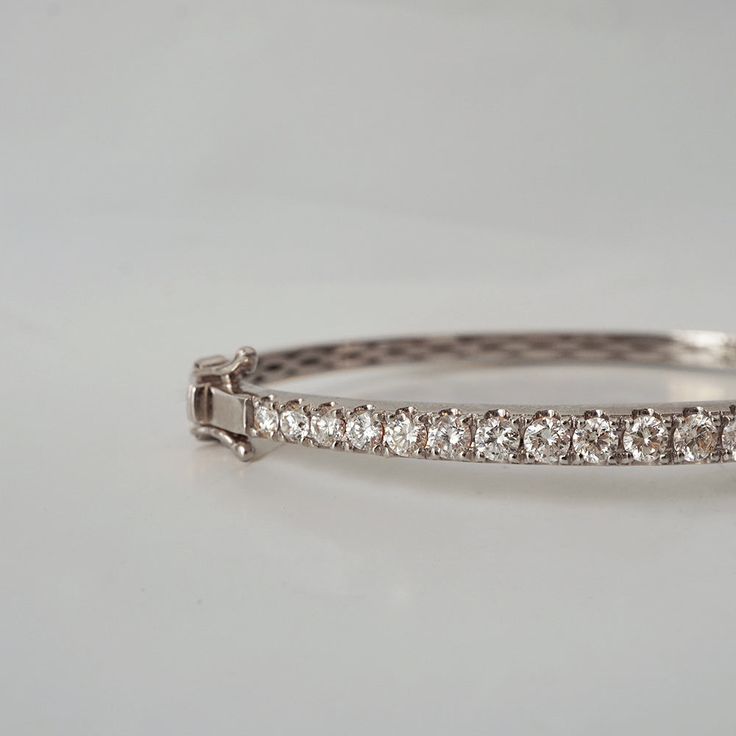 This stunning diamond bangle is a classic design that can be worn for any events. Featuring over a total of approximately 2 carat natural white diamonds framed in 14K and 18K solid gold. The bangle has a slightly tapered band creating a feminine look. Put together with a box clasps and a safety hinge. Handcrafted in 14K Yellow gold, rose gold and white gold. Model is wearing 6.5" bracelet. 14K or 18K solid gold 25 Natural white brilliant cut diamonds. SI clarity GH color, Approx 2 ct total carat Wedding Brilliant Cut Yellow Gold Bangle, Wedding Yellow Gold Bangle With Brilliant Cut, Wedding Bangle In Yellow Gold With Brilliant Cut, Yellow Gold Diamond Bracelet With Vvs Clarity For Wedding, White Gold Round Bangle For Everyday Luxury, Classic Yellow Gold Diamond Bangle, Luxury Brilliant Cut Bangle For Anniversary, White Gold Diamond Bangle With Brilliant Cut, Formal Oval Diamond Bracelet With Single Cut Diamonds