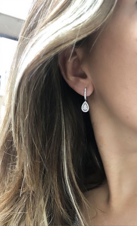 a close up of a person wearing some kind of earring on their ear and looking at the camera