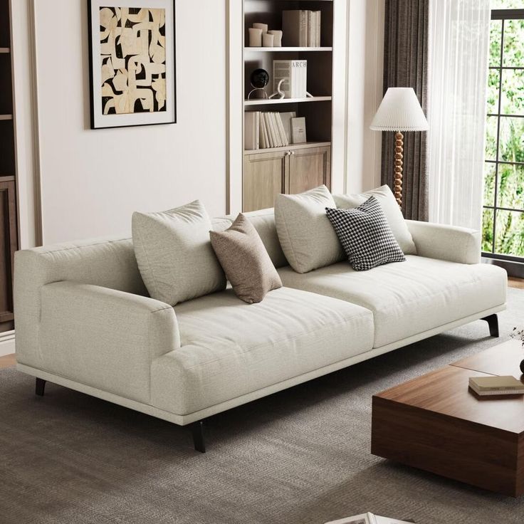 a living room with two couches and a coffee table in front of a window