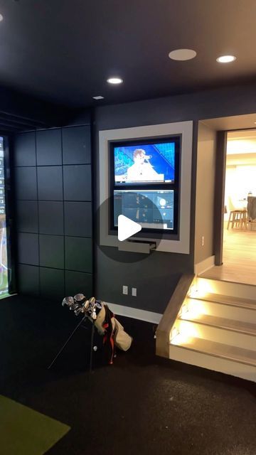 a dog is sitting on the floor in front of a flat screen tv and some stairs