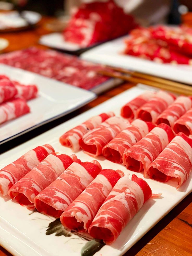 several different types of meats on white plates