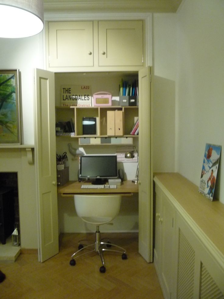 an office with a desk, computer monitor and bookshelf in the doorway to another room