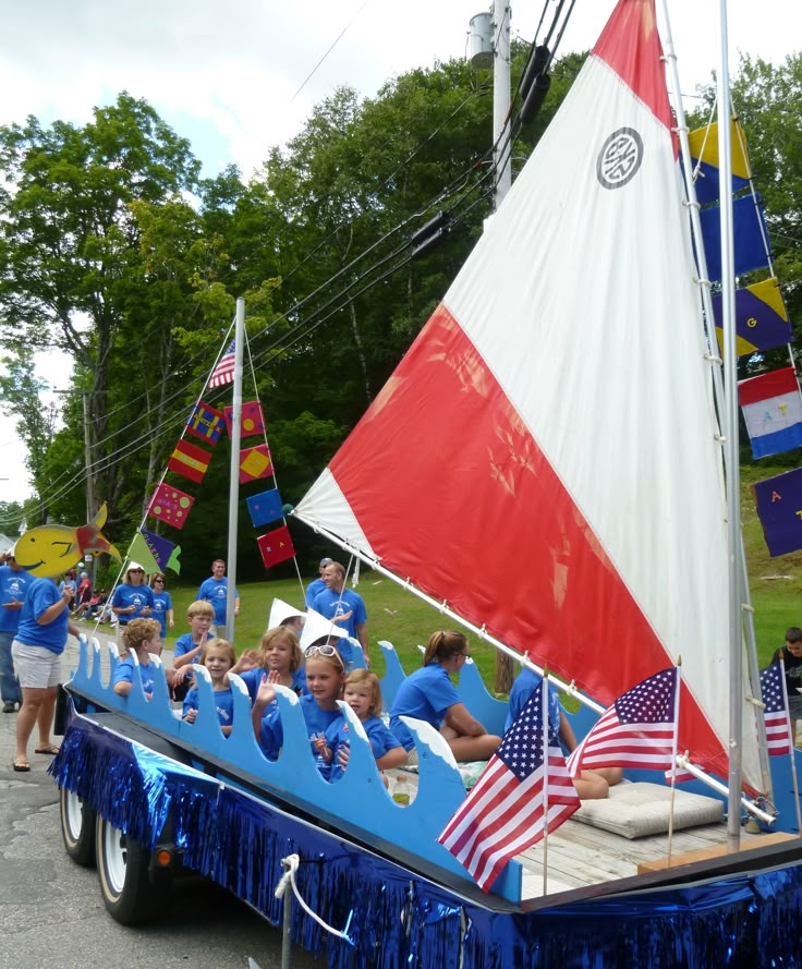 a group of people riding on the back of a blue and white boat with american flags