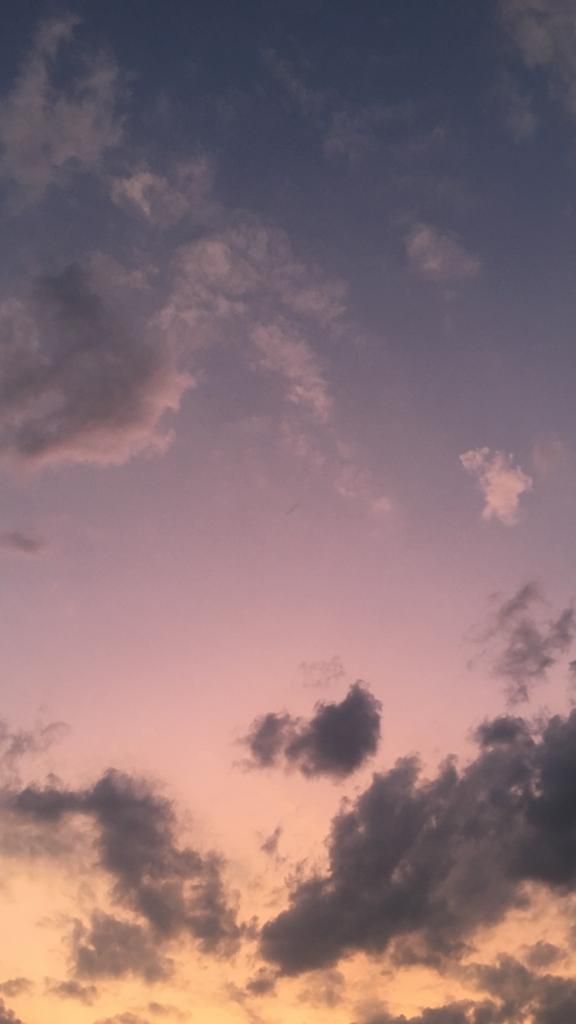 an airplane is flying in the sky at sunset