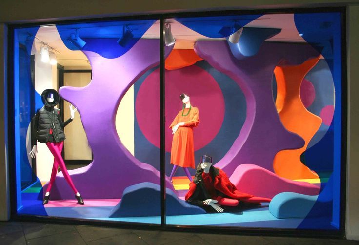 two mannequins dressed in bright colored clothing are seen through the window display