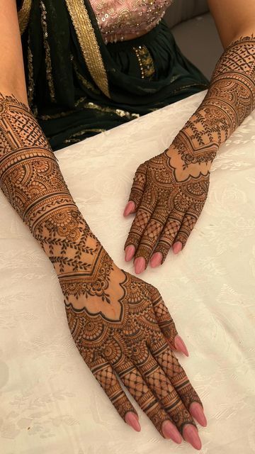 a woman sitting on top of a bed covered in henna