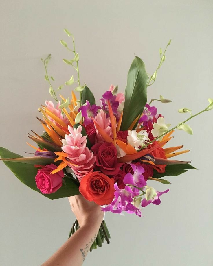 a person holding a bouquet of flowers in their hand