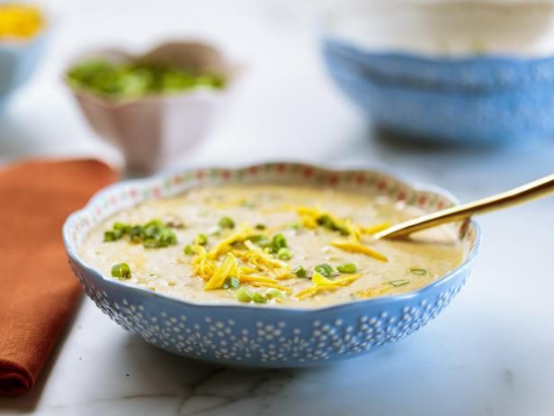 a blue bowl filled with soup and topped with cheese